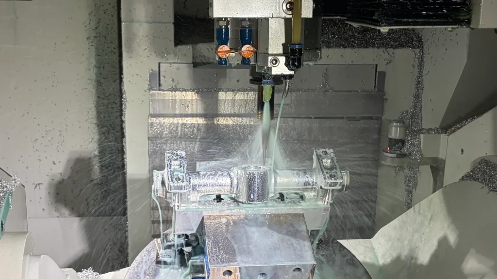 CNC machining setup showing a cutting tool, clamped workpiece and coolant