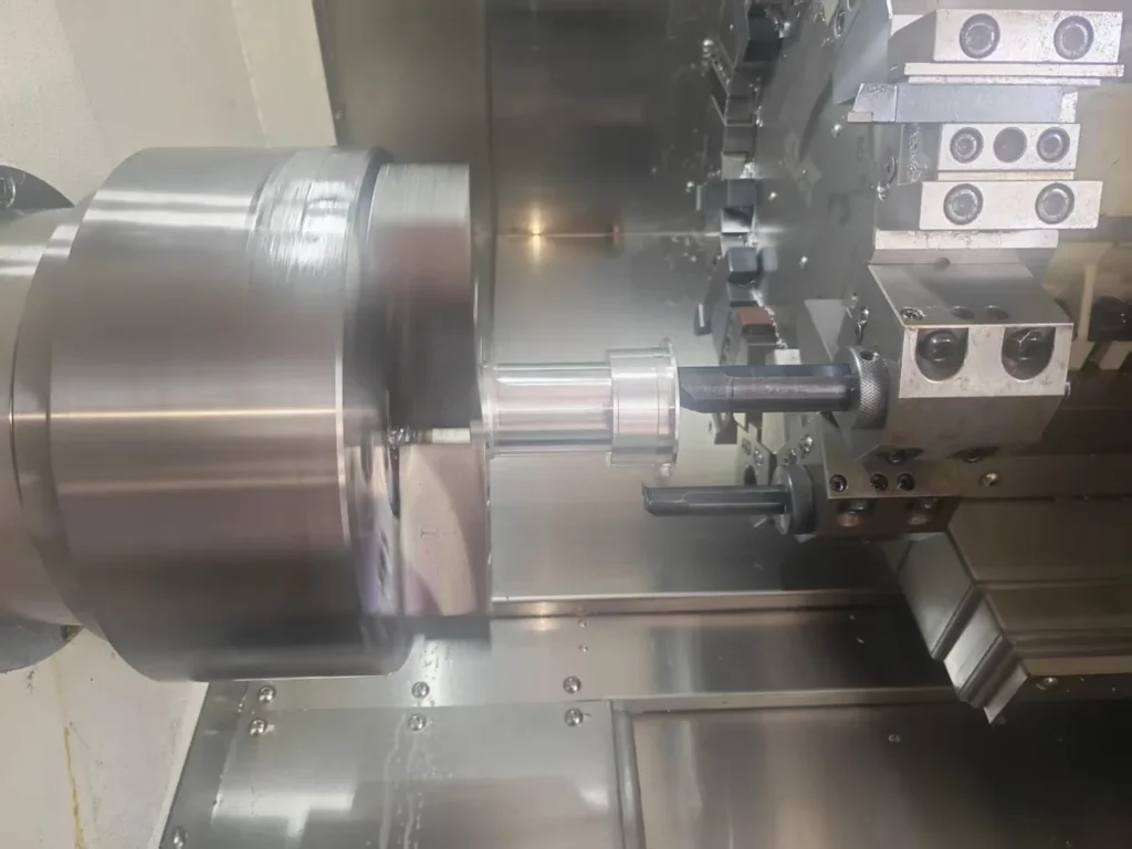 CNC lathe with a rotating workpiece held in the chuck and a tool positioned at its bore