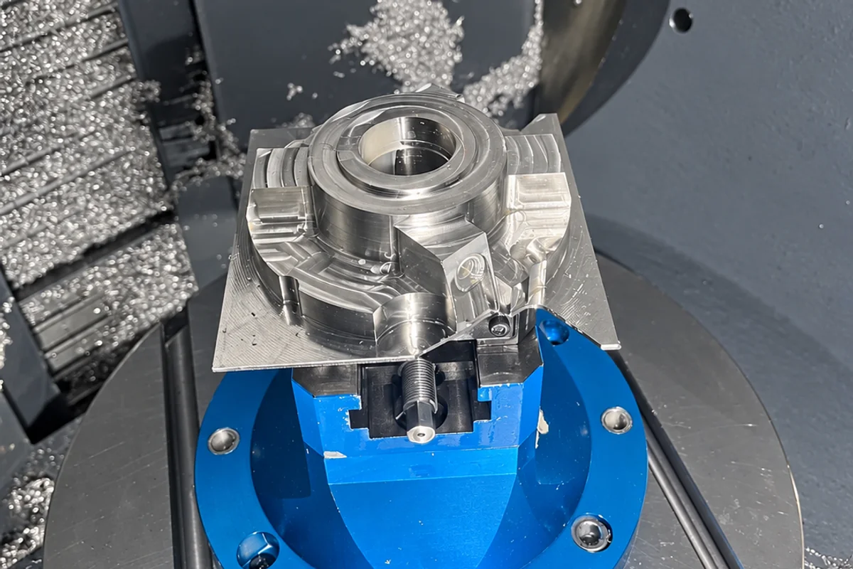 Titanium workpiece held in a blue CNC machining fixture at SAMSHION