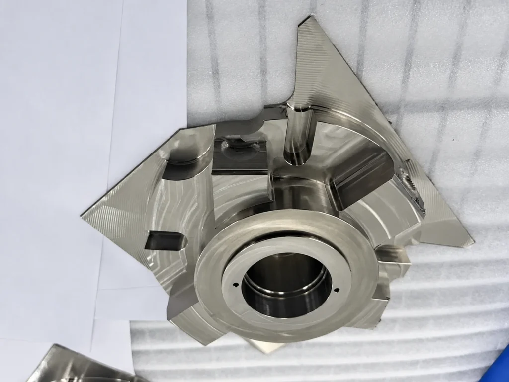 CNC machined titanium component with a central bore and milled recesses