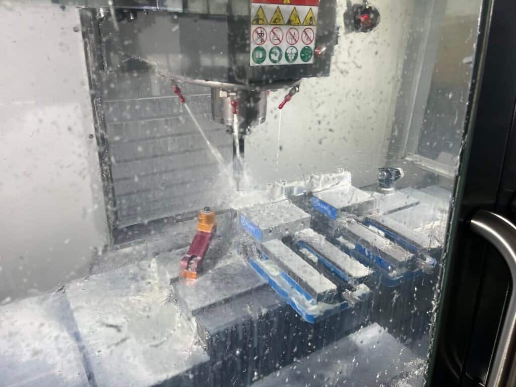 CNC milling 304 stainless steel using coolant to prevent work hardening and extend tool life.