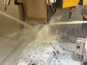 CNC milling machine cutting a custom metal part with precision tooling and coolant