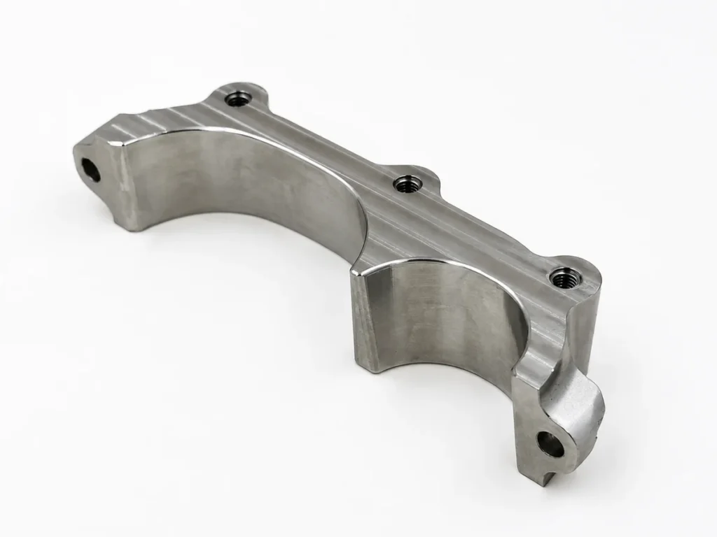 CNC-milled stainless steel component with curved profiles and threaded holes
