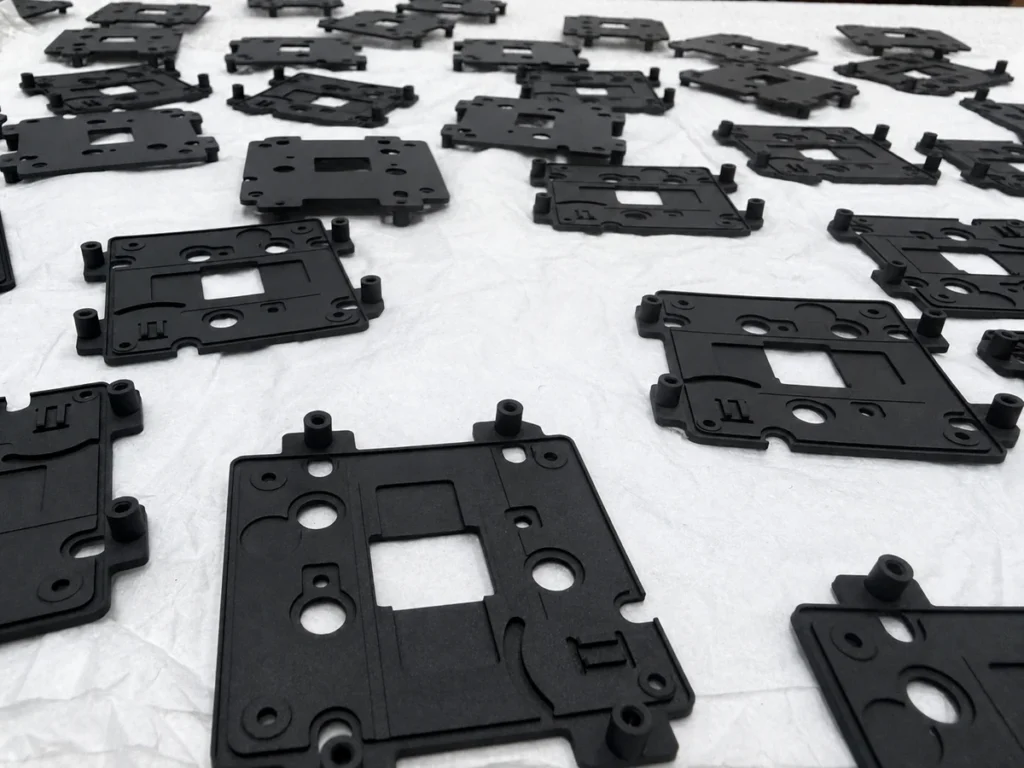 Low-volume batch of black CNC-milled components arranged on a protective surface