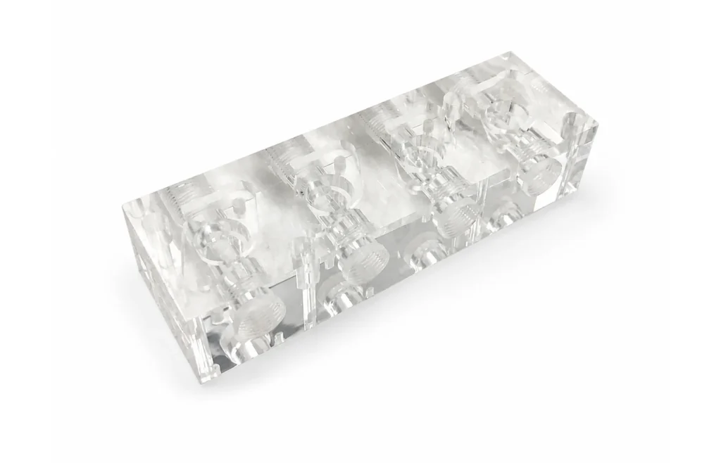 Transparent PMMA acrylic CNC machined component with complex internal cavities and circular features