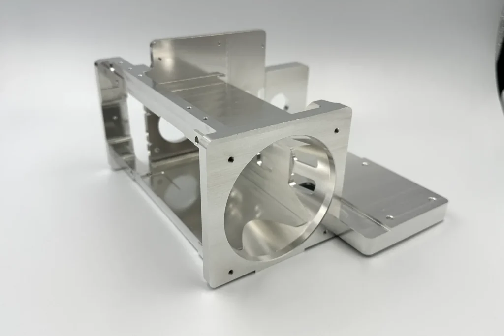 One-piece CNC machined aluminum bracket with large bores and mounting faces for infrared equipment
