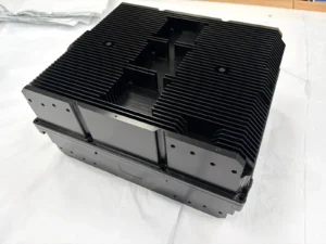 Black-finished aluminum enclosure component with external fins and machined mounting holes