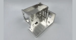 CNC machined metal bracket with mounting faces, slots, and circular openings