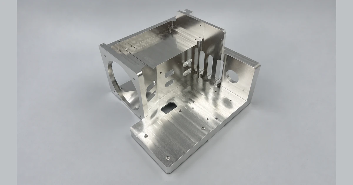 CNC machined metal bracket with mounting faces, slots, and circular openings