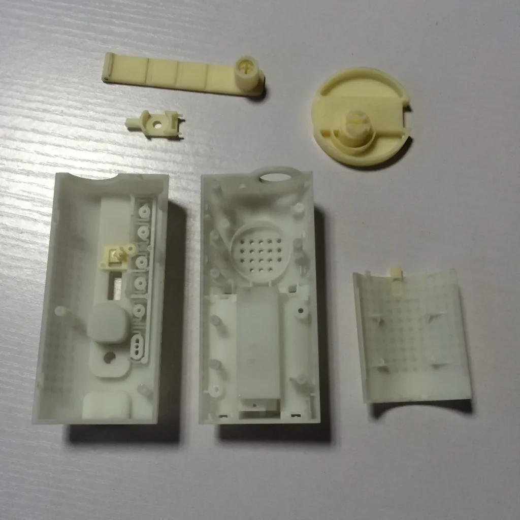 CNC machined ABS housing halves and separate components arranged before assembly