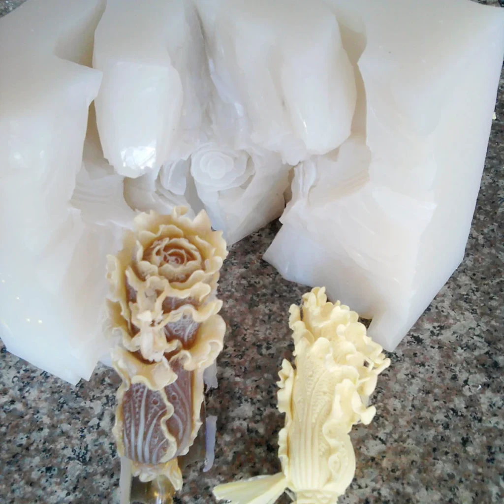 Elaborately patterned parts beside a silicone mold opened along its normal cut parting surfaces