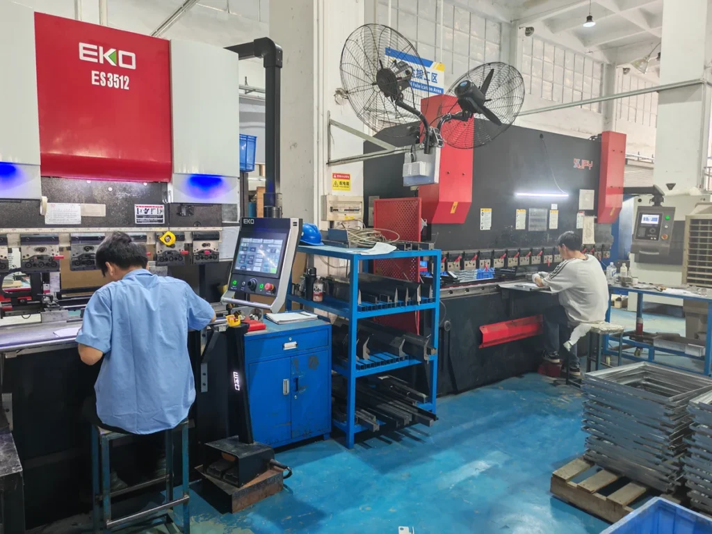 Operators working at press brake machines in a sheet metal bending workshop