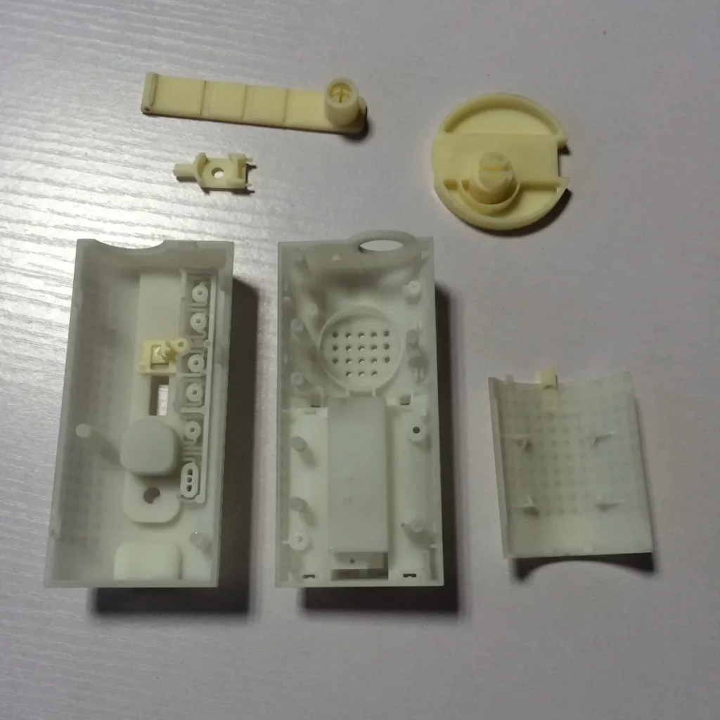 CNC-machined ABS prototype housing halves and separate components laid out before assembly