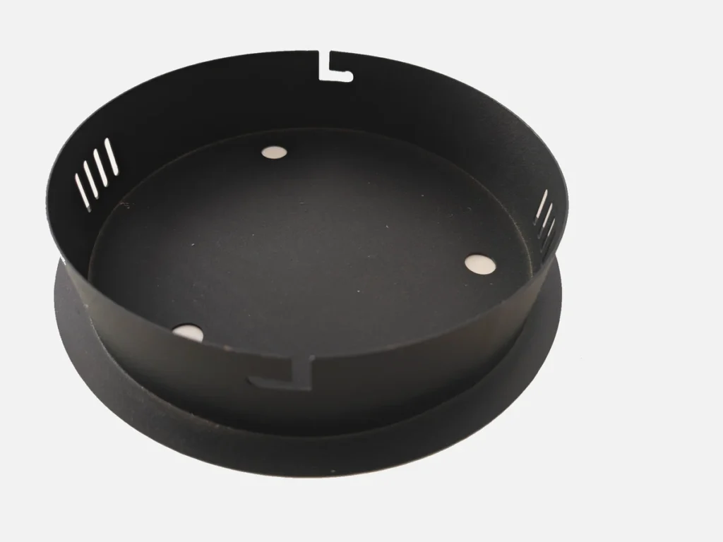 Black powder-coated circular sheet metal bottom cover with mounting holes and ventilation slots