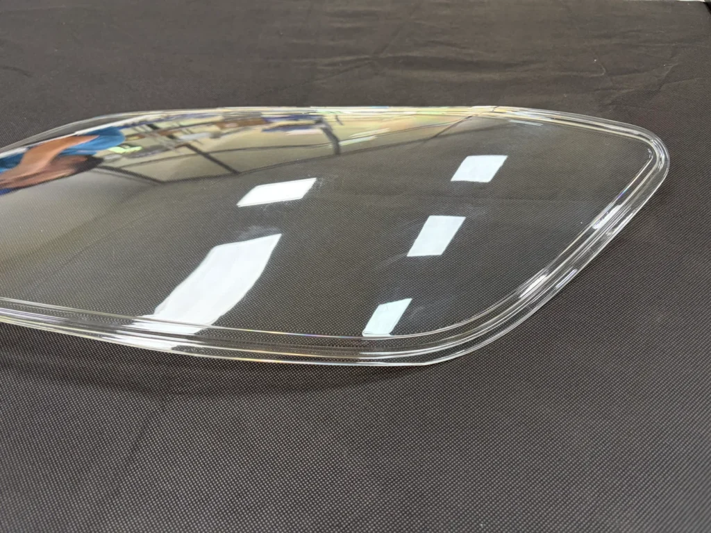 Clear PC automotive lamp cover with a curved profile and raised perimeter edge