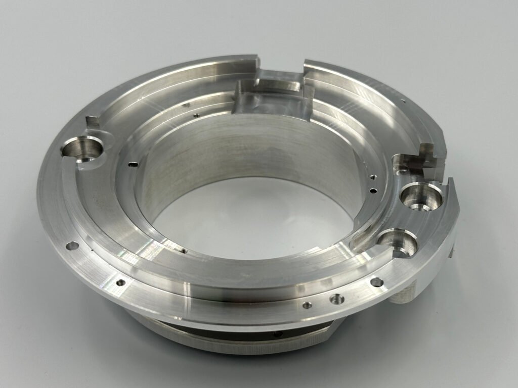 As-machined 6061-T6 aluminum ring-shaped component with stepped surfaces, grooves and holes.