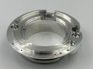 As-machined 6061-T6 aluminum ring-shaped component with stepped surfaces, grooves and holes.