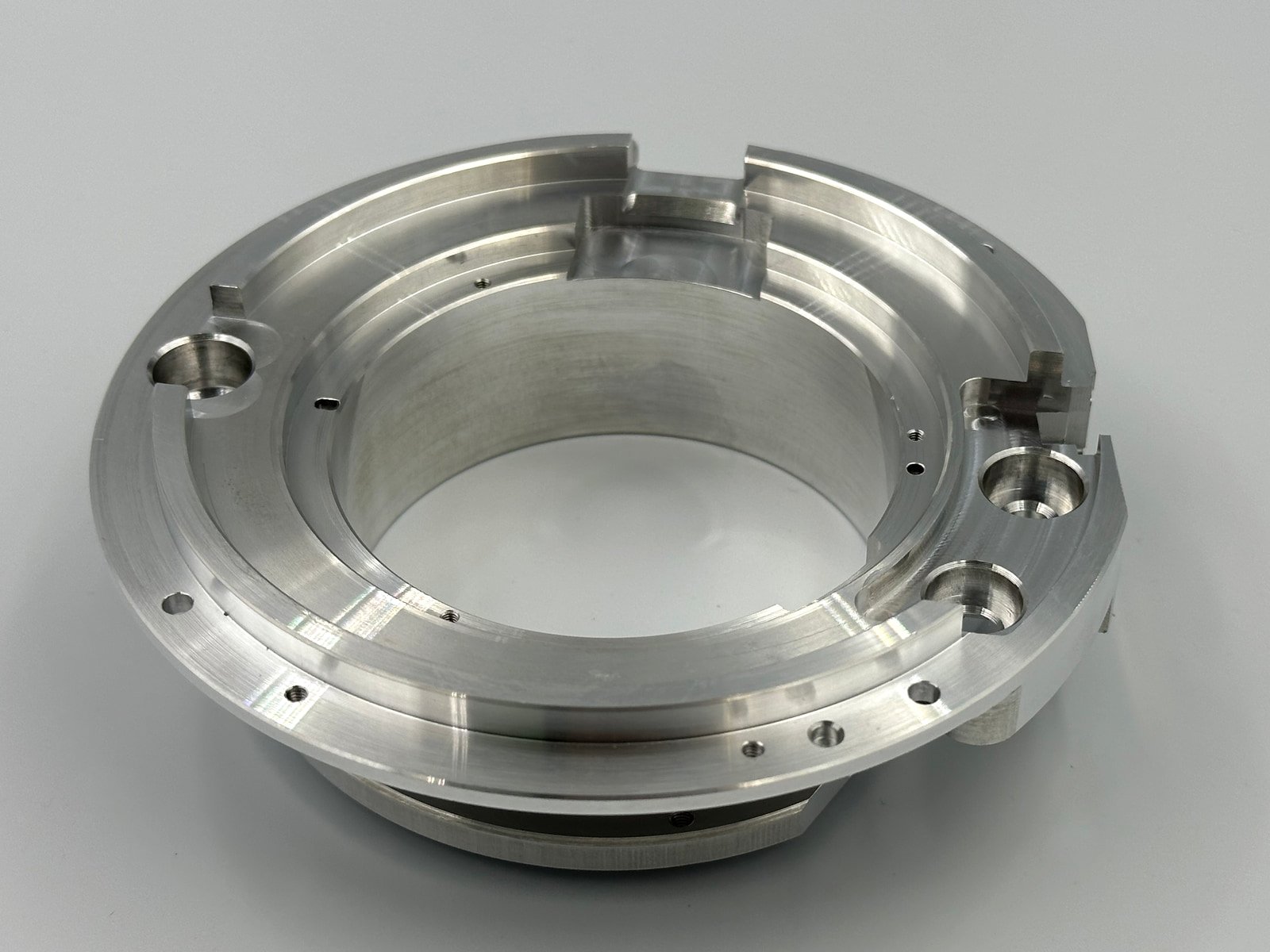 As-machined 6061-T6 aluminum ring-shaped component with stepped surfaces, grooves and holes.