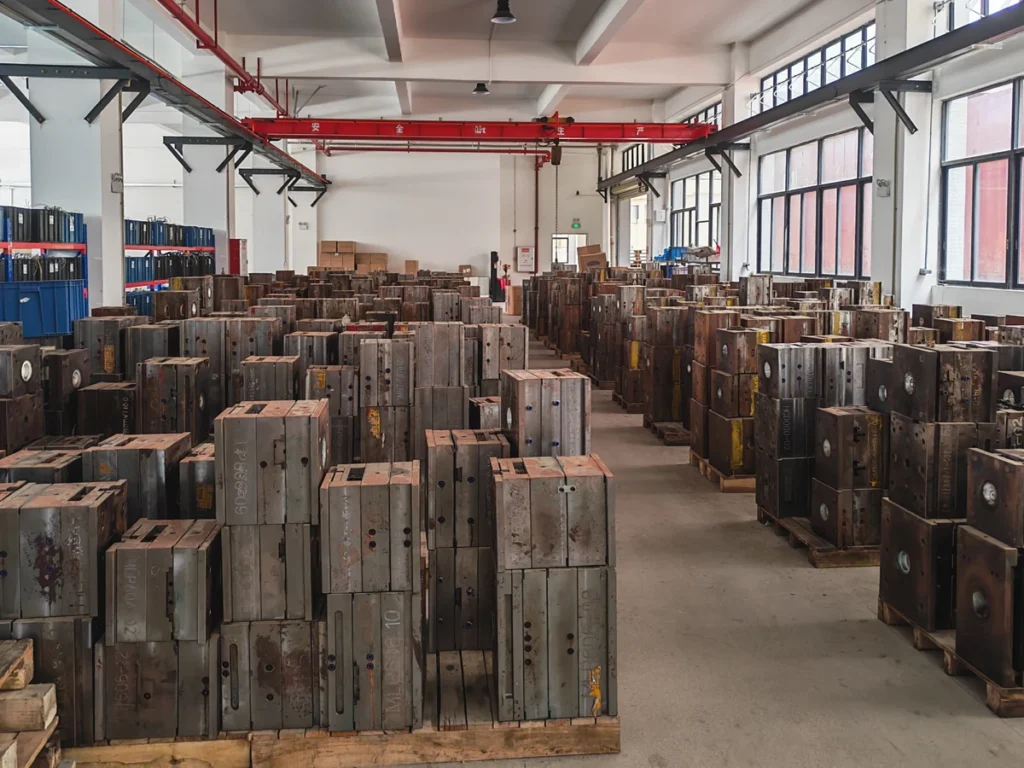 Injection molds arranged on wooden pallets inside a tooling storage area.