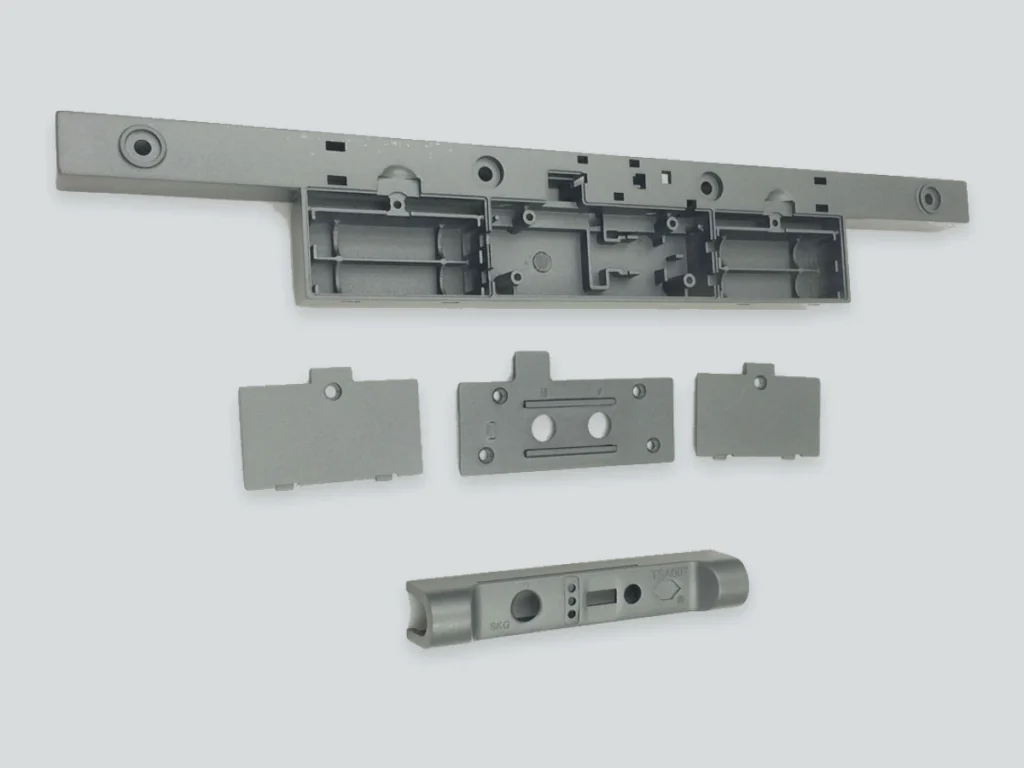 Gray-painted ABS+PC combination lock components, including a long structural part and mating cover pieces.