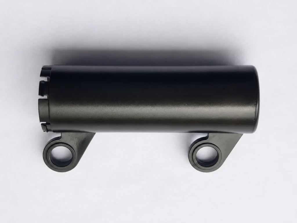 Black PC+ABS injection-molded cylindrical component with two side tabs and circular openings.