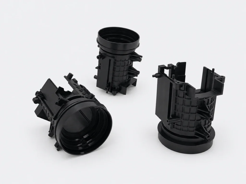 Three black injection molded housings with circular openings, reinforcing ribs and mounting features.