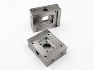 As-machined 304 stainless steel component shown in two orientations with pockets and threaded holes