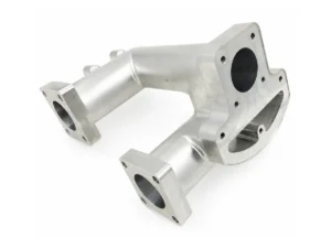 Aluminum manifold with angled flange faces and visible threaded holes