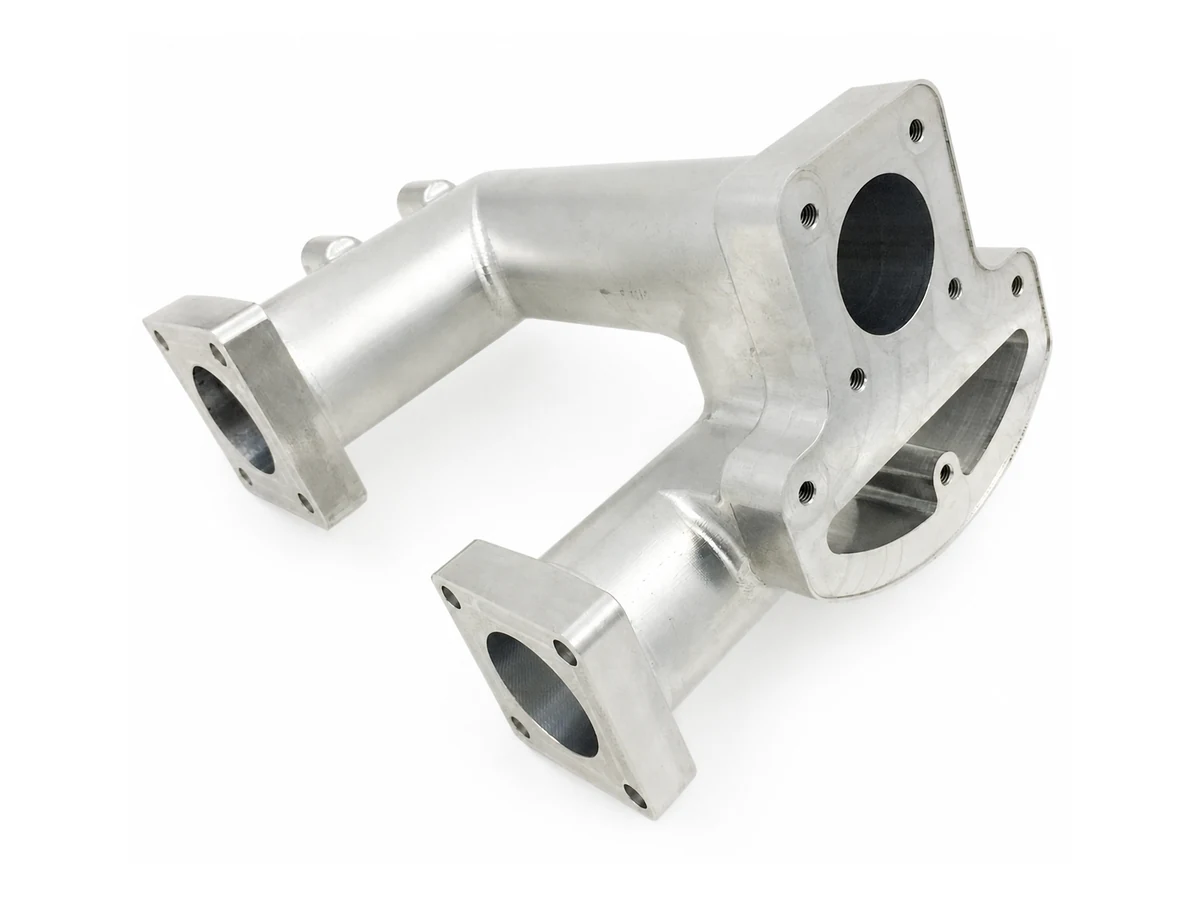 Aluminum manifold with angled flange faces and visible threaded holes