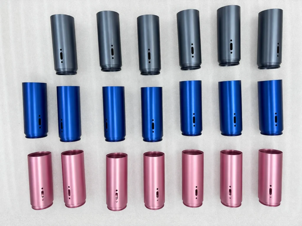 Gray blue and pink anodized cylindrical housings arranged on protective foam