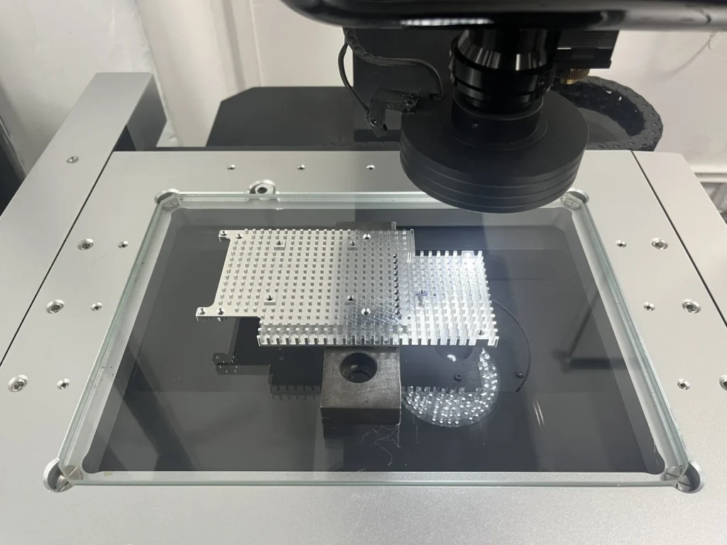 Machined pillar array plates on the glass stage beneath an optical measuring lens